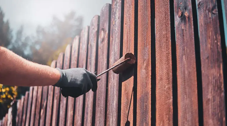 diligent man is painting fence with brush 2021 08 28 11 14 27 utc