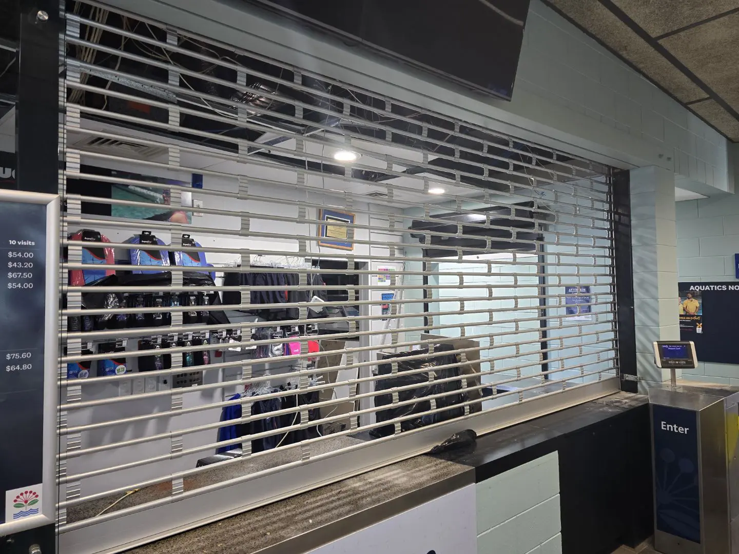Clear-view roller grille lowered across a shop counter
