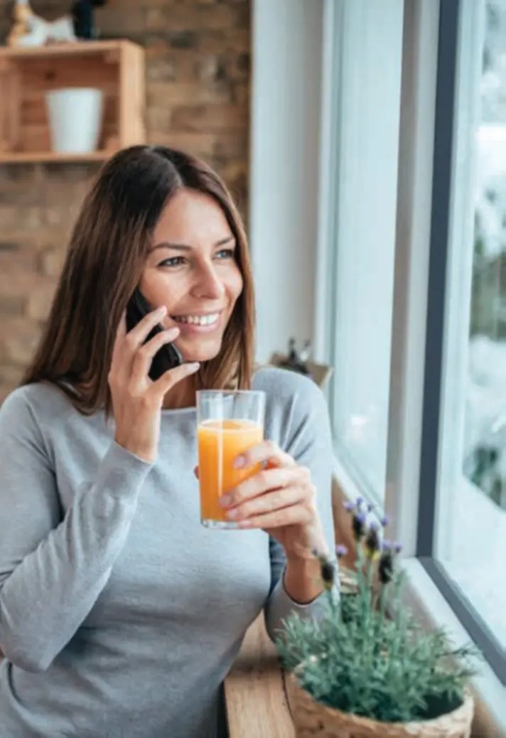 Woman relaxing by a window in a warm home fitted with double glazing